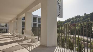 Un área de estar al aire libre, moderna, con sillas blancas y un letrero que dice "Radisson".