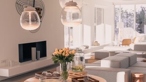 Uma sala de estar moderna com uma mesa redonda, um vaso de flores e uma lareira.