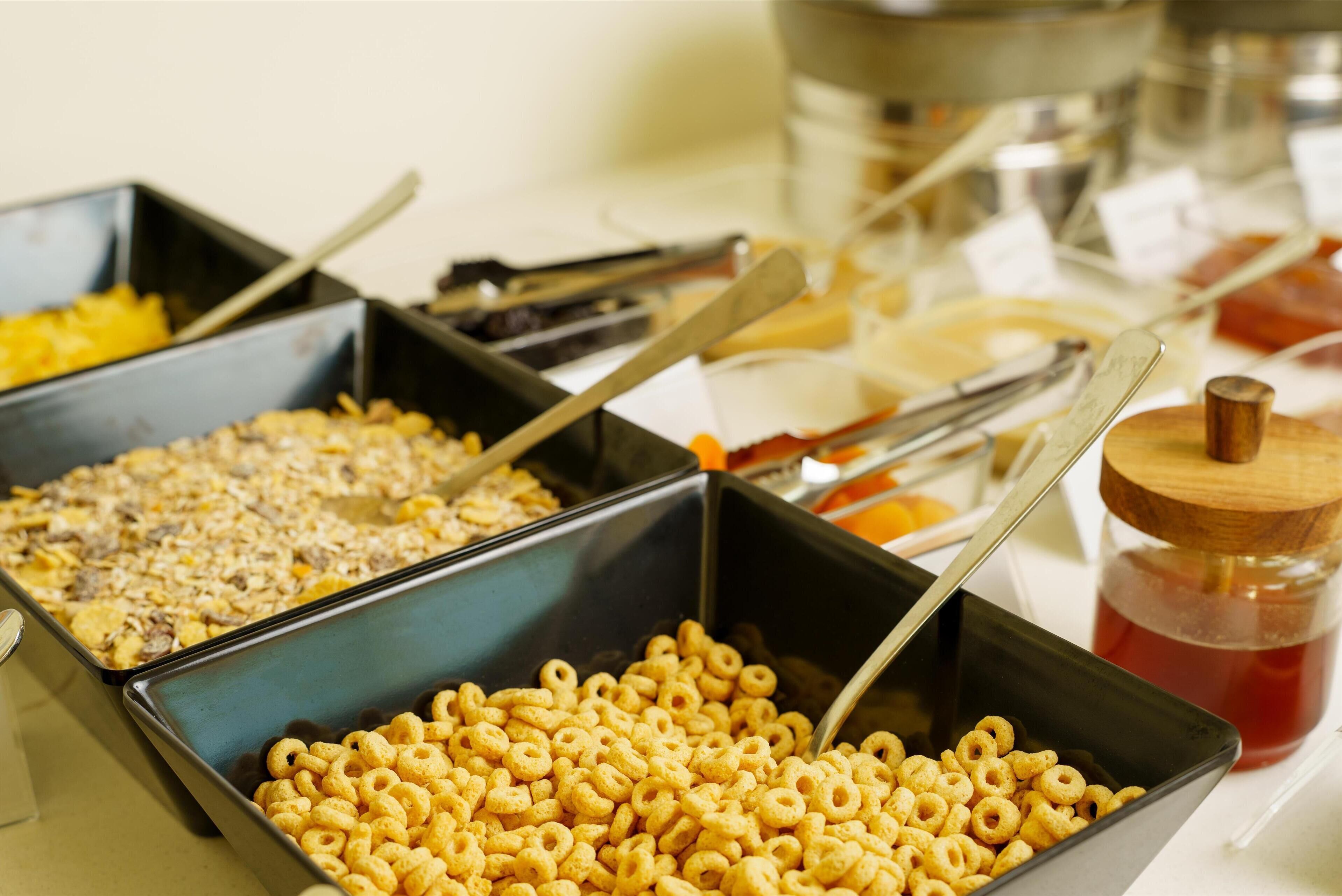 Un bufé con diferentes opciones de comida, incluyendo cereales y otros bocadillos.