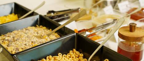 Un bufé con diferentes opciones de comida, incluyendo cereales y otros bocadillos.