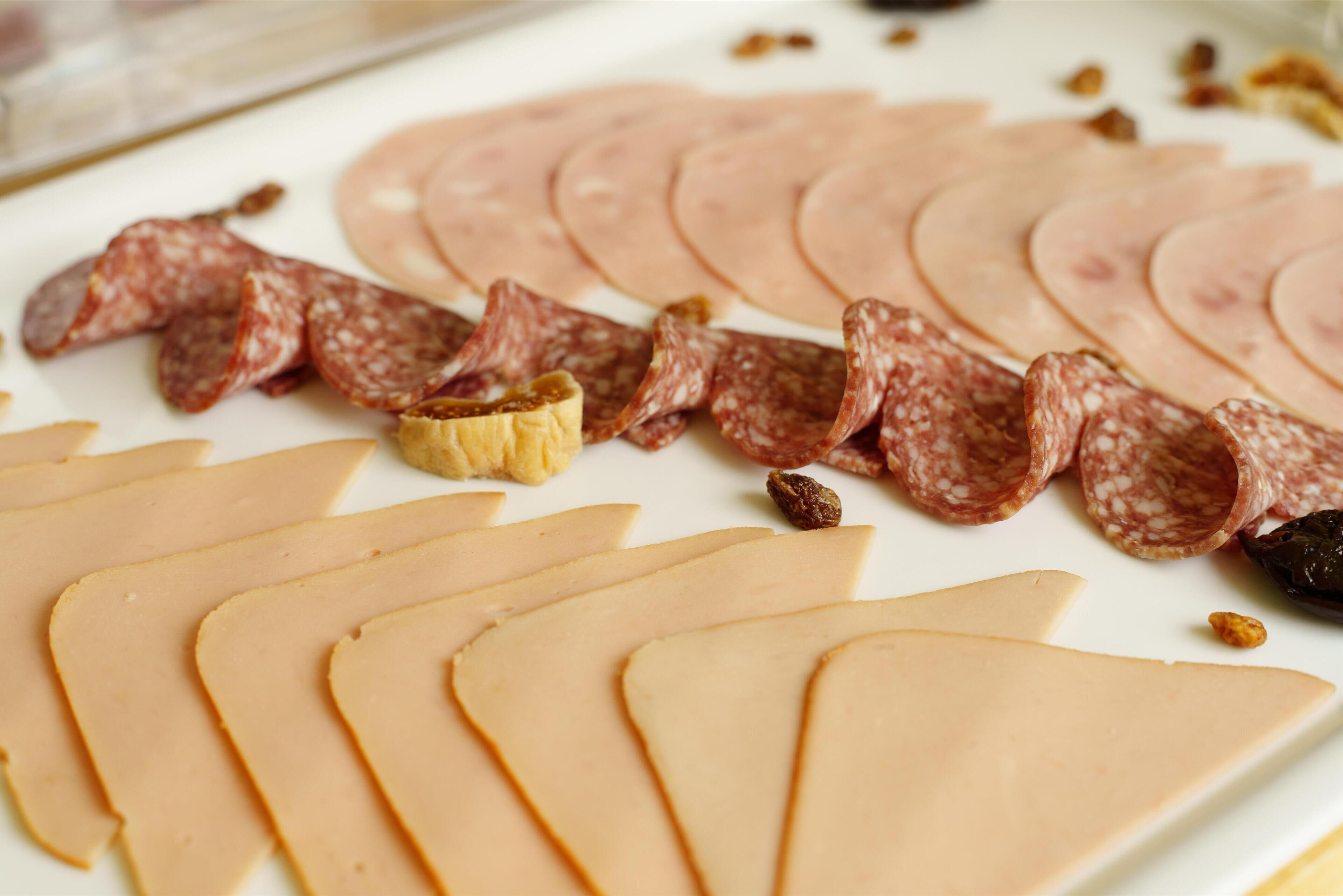 Una variedad de embutidos y quesos dispuestos en un plato.