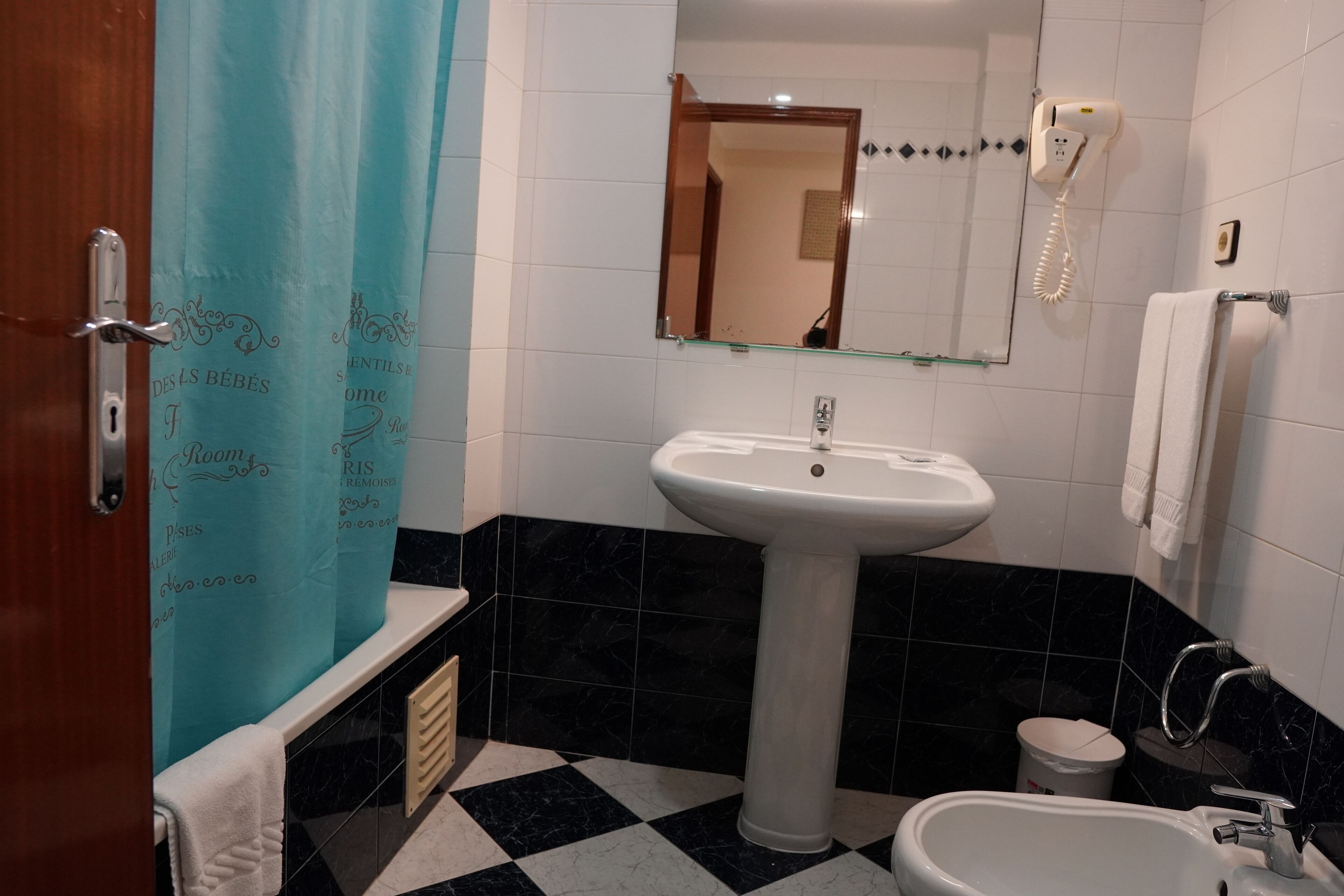 Une salle de bain équipée d’un lavabo, d’un miroir et d’un téléphone.
