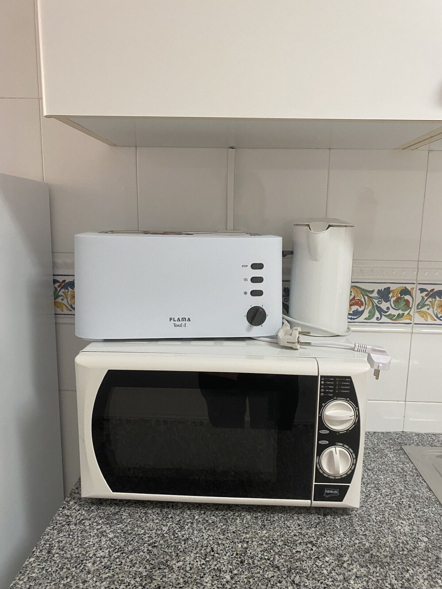 Eine Küche mit einem weißen Toaster und einer Mikrowelle auf einer Arbeitsplatte.
