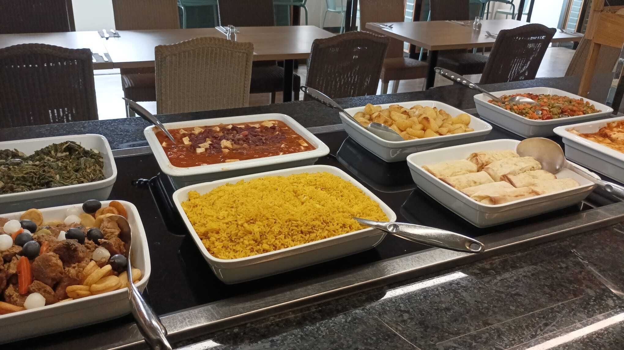En buffé med olika rätter, inklusive ris, bönor och blandade grönsaker.