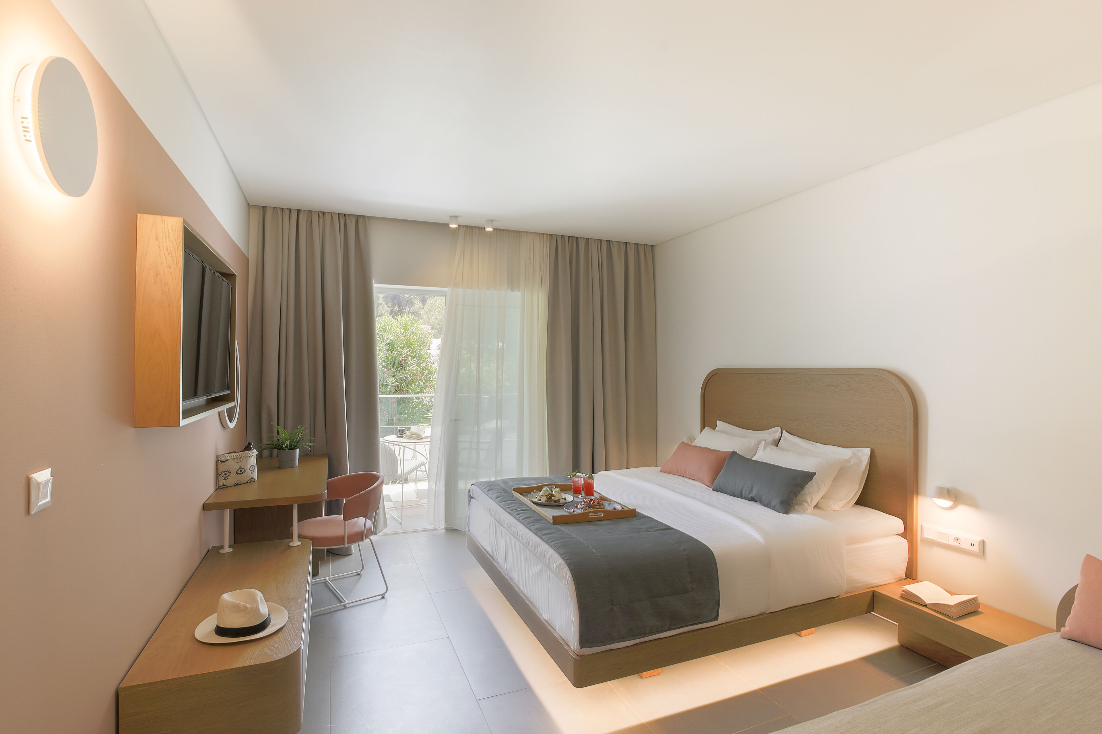 Een moderne hotelkamer met een groot bed, een bureau, een stoel en een klein balkon.