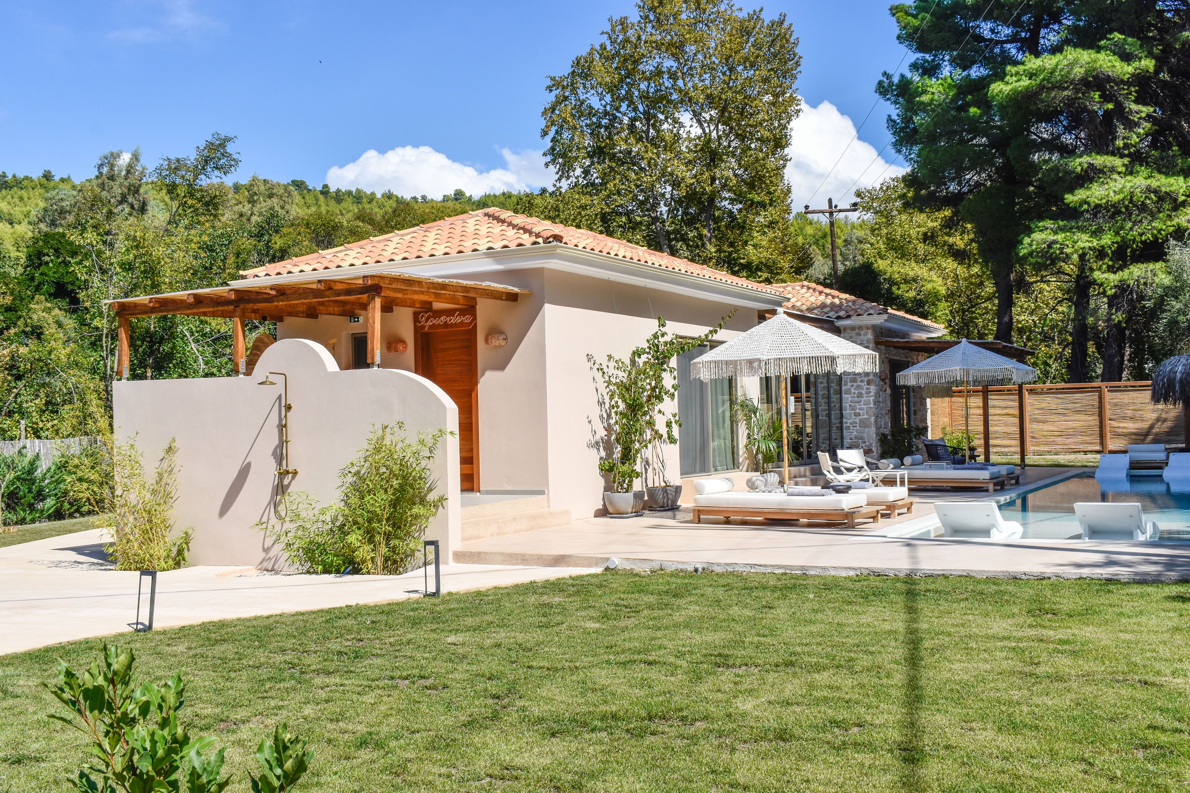 A modern house with a swimming pool, outdoor seating, and a garden.