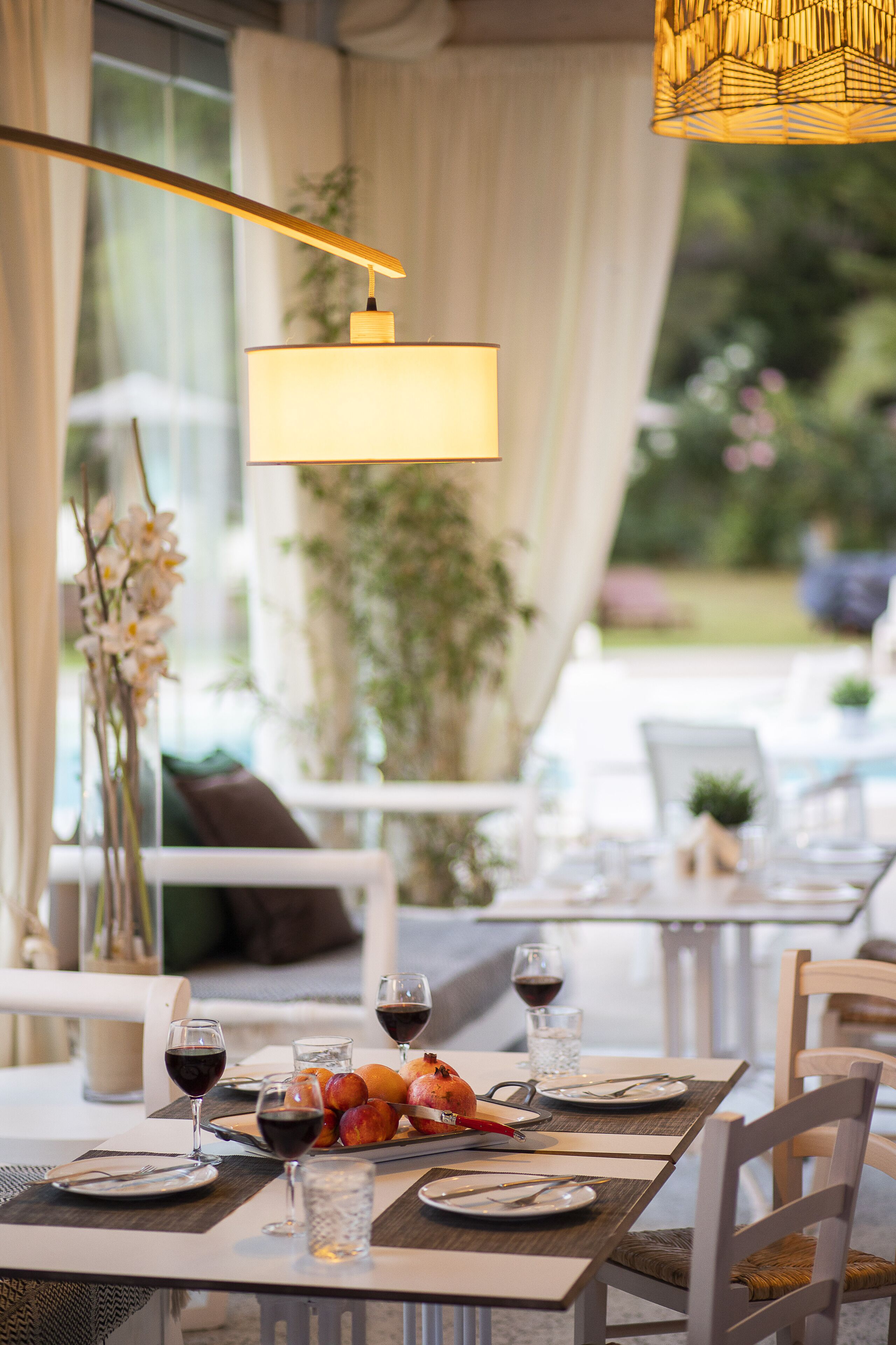 A dining table set with plates, cutlery, glasses, and a fruit platter.