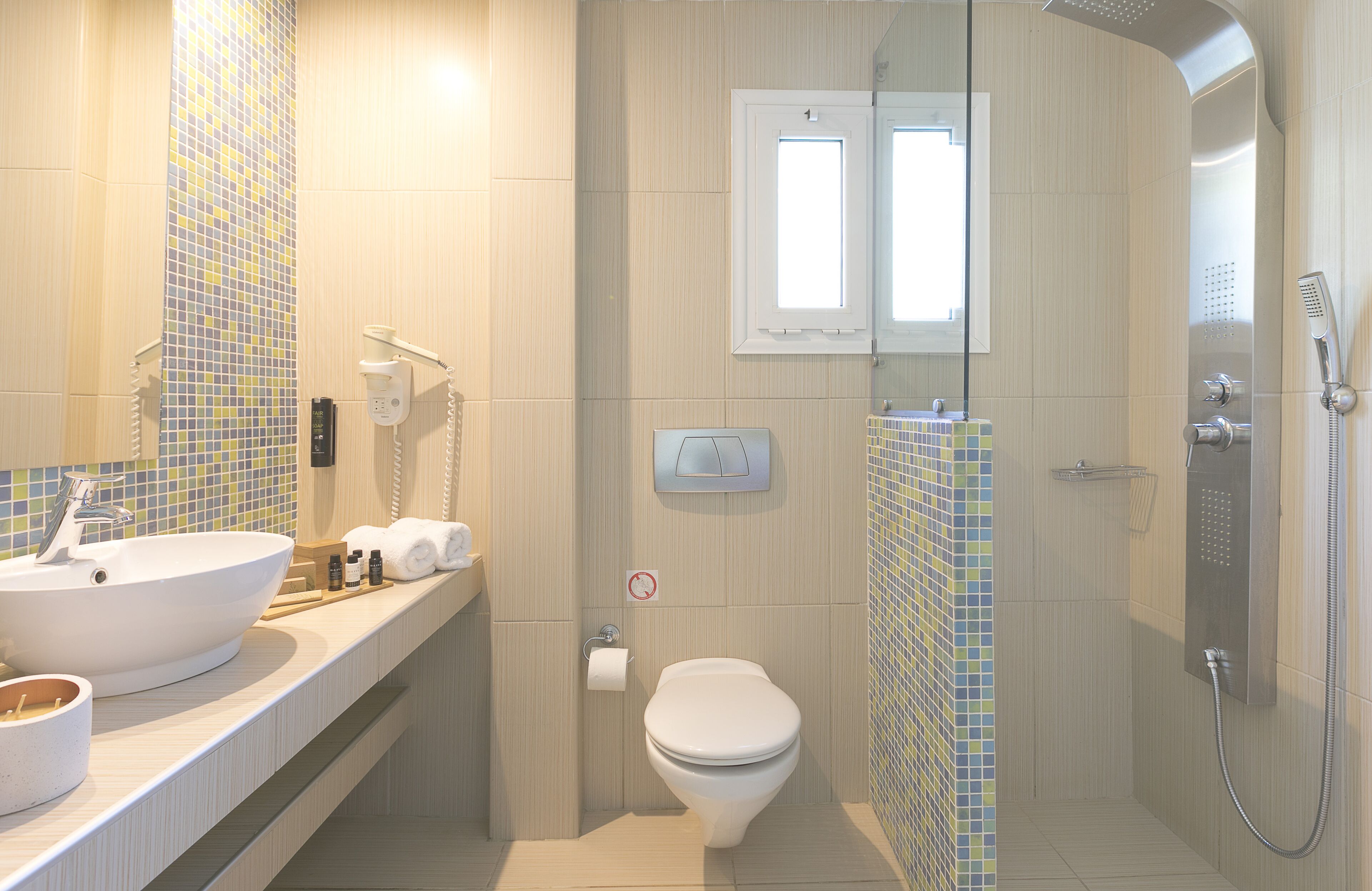 A modern bathroom with a large sink, toilet, and shower.