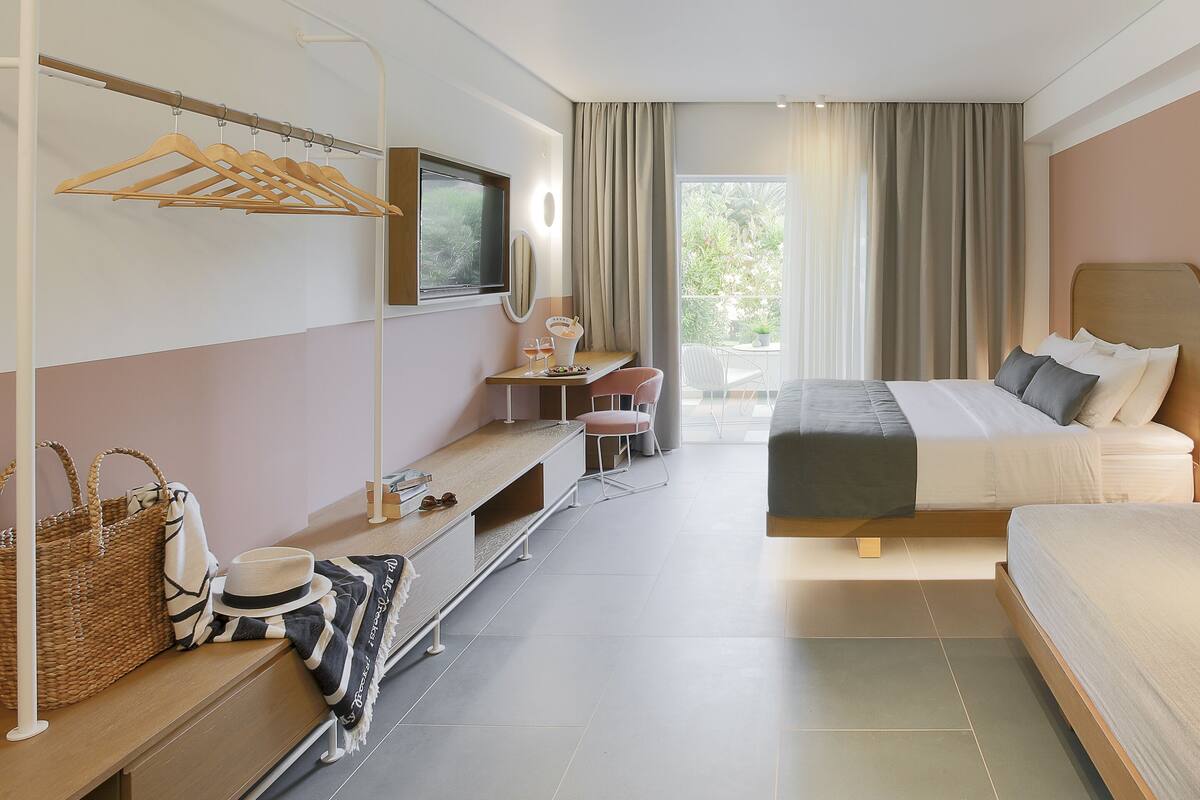 Een moderne hotelkamer met een bed, bureau, stoel en een klein balkon.