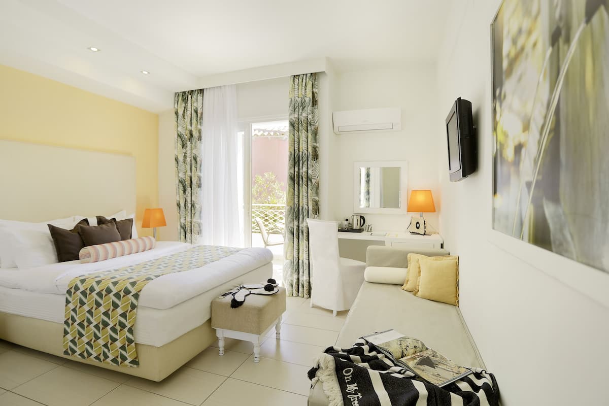 Een hotelkamer met een bed, een bureau, een stoel, een bank en een televisie.