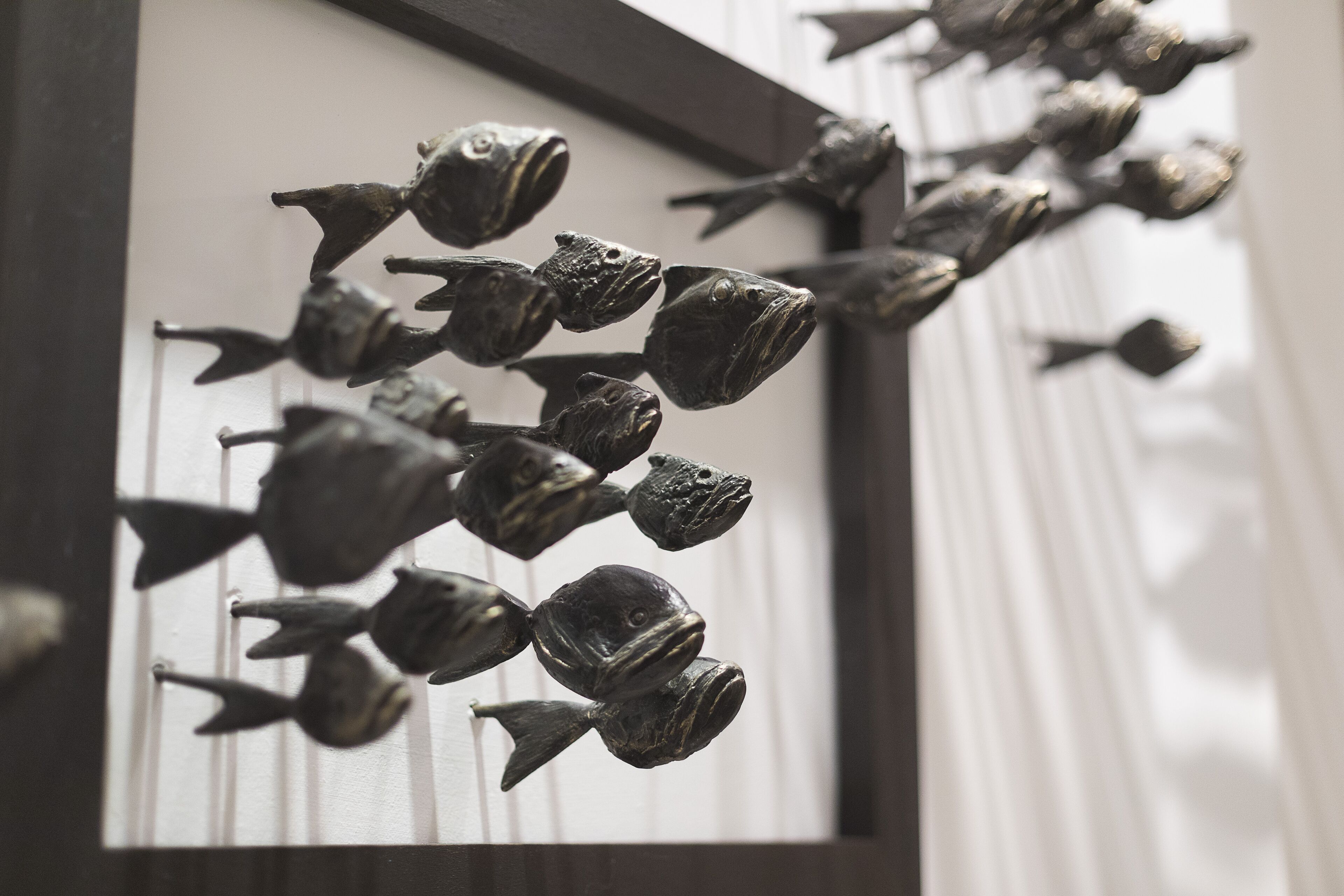 A series of fish-shaped sculptures on a wall.