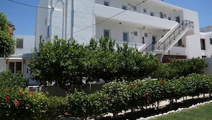 A modern white building with multiple floors, a staircase, and satellite dishes on the roof. - Skoufezis Studios (Kos)