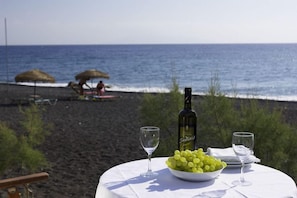 On the beach, black sand, sun loungers, beach umbrellas