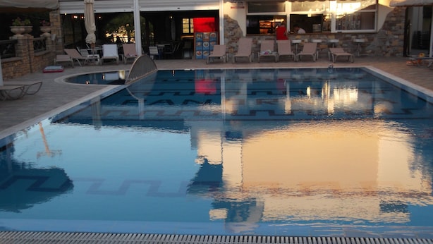 An indoor swimming pool with lounge chairs and a bar area. - Panorama Studios (Rhodes)