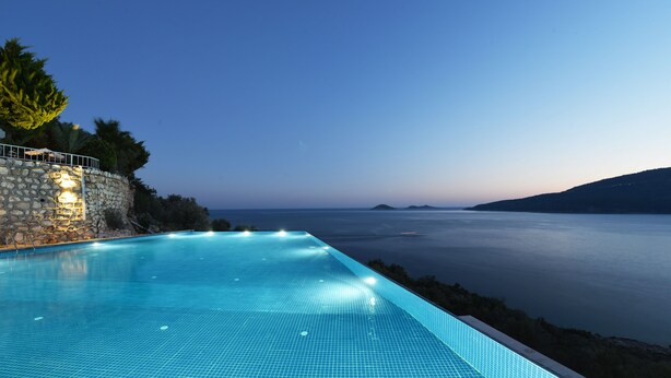 A swimming pool with a view of the sea at dusk. - Kalamar Hotel (Kas)