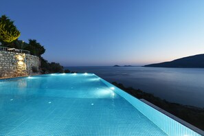 A swimming pool with a view of the sea at dusk. - Kalamar Hotel (Kas)