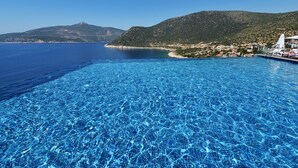 A clear blue sea with a swimming pool and a mountainous landscape in the background. - Kalamar Hotel (Kas)