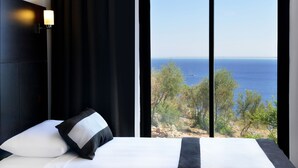 A bedroom with a large window overlooking a coastal landscape. - Kalamar Hotel (Kas)