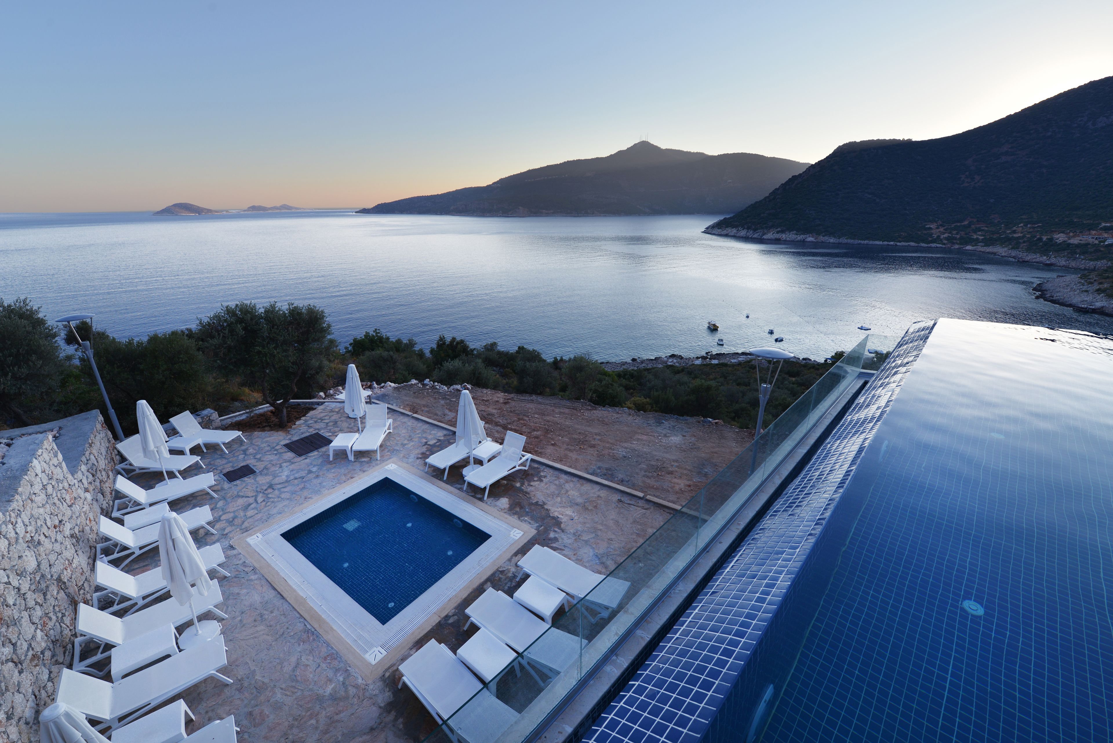 Une piscine à débordement située sur le toit, offrant une vue sur la mer et les montagnes.