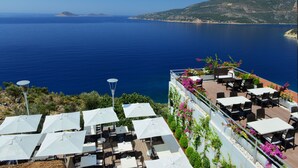 A rooftop terrace with outdoor seating, overlooking a coastal view. - Kalamar Hotel (Kas)
