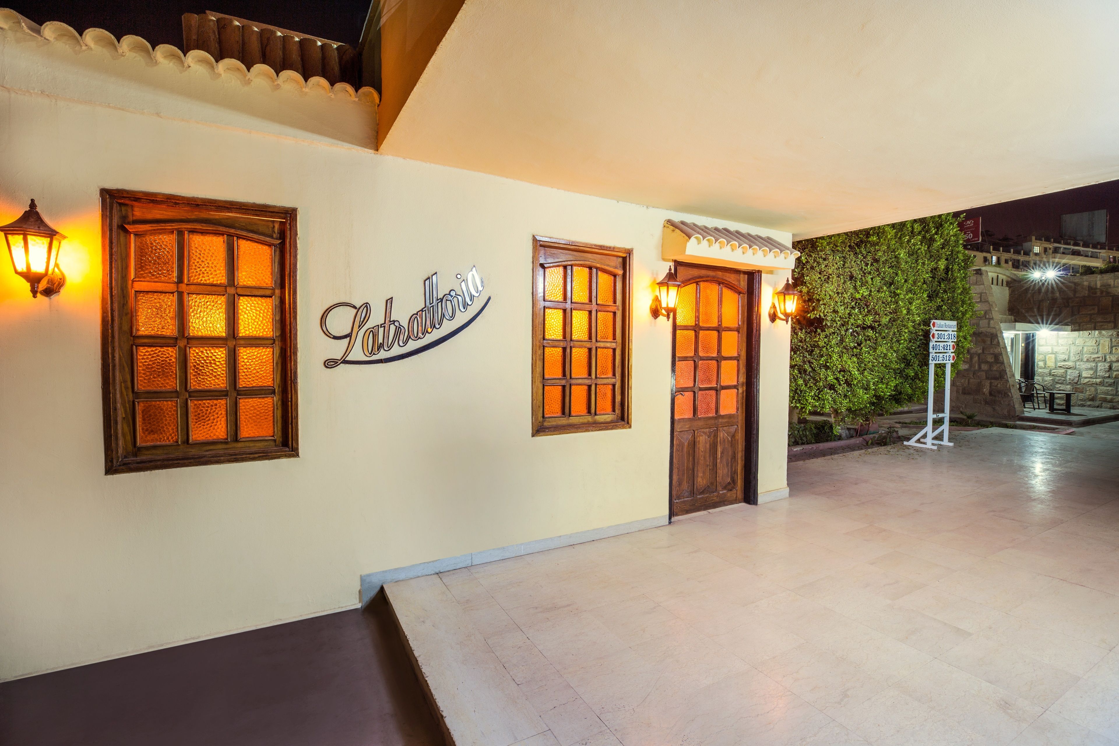 A hotel entrance with a sign reading "La Balloria," featuring traditional wooden doors and windows with warm lighting.