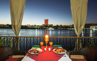 Mesa para dos con vista a una masa de agua y una torre al fondo.