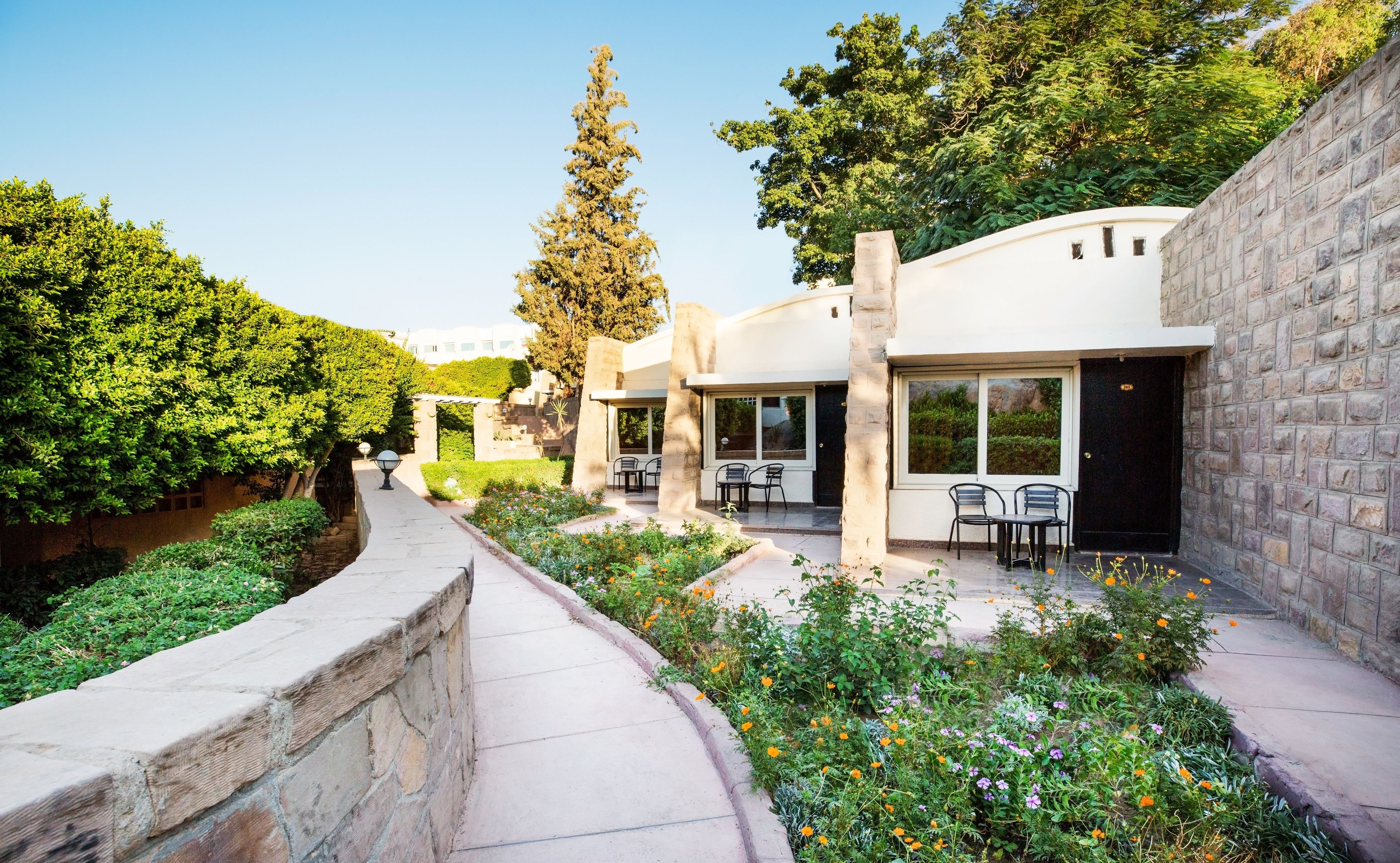 A modern building with outdoor seating and a stone pathway.