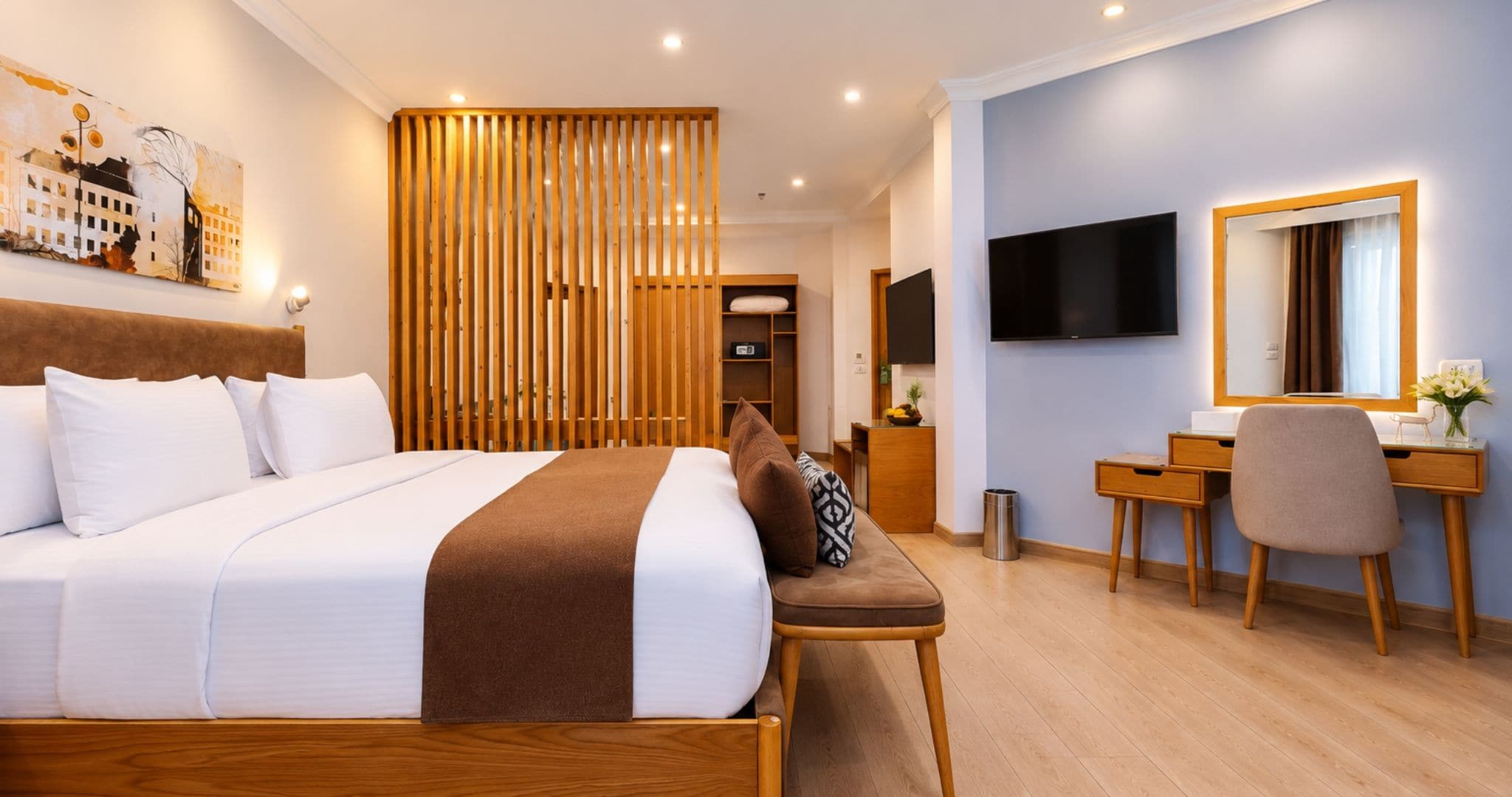 Une chambre d’hôtel équipée d’un lit, d’un bureau, d’une chaise, d’une télévision et d’une cloison en bois.