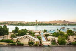 A coastal hotel with multiple buildings, a swimming pool, and boats in the water. - Obelisk Nile Hotel Aswan (Aswan)