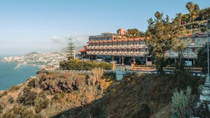 A coastal hotel with multiple balconies, a view of the sea, and a mountainous backdrop. - Hotel Ocean Gardens (Funchal)