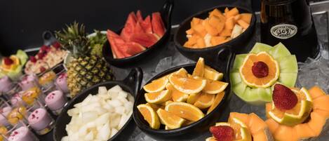 A variety of fruits and beverages on a table with ice.