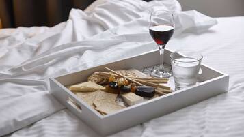 A tray of snacks and drinks on a bed with white bedding.