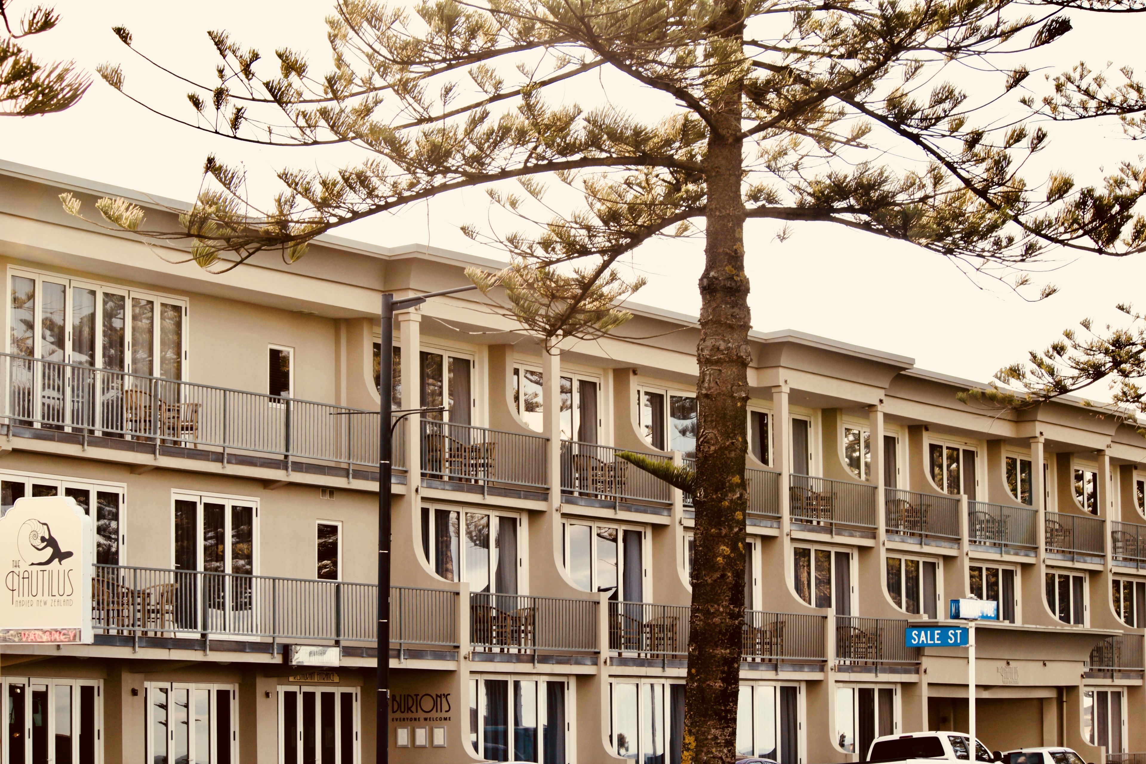 Un hôtel à plusieurs étages doté de balcons, une enseigne pour le restaurant «The Cautius», et un panneau indiquant la rue «SALE ST».