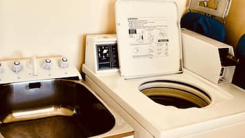 Una lavadora de carga frontal con un lavamanos de acero inoxidable y un panel de control con opciones de ciclo.