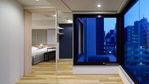 A modern hotel room with a large window, a bed, and a wooden floor. - City Hotel N.U.T.S. (Tokyo)