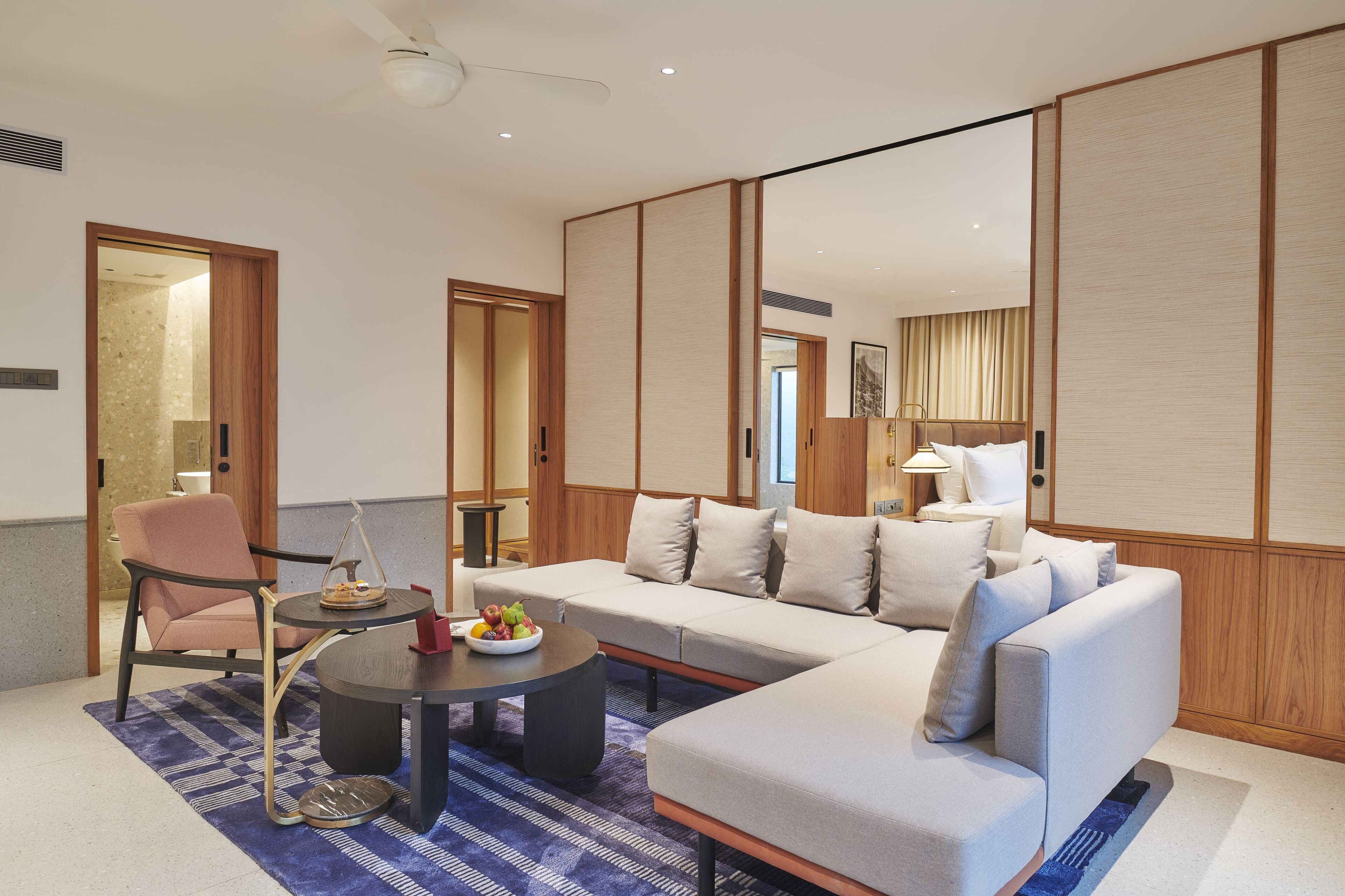 Uma sala de estar moderna com um sofá, poltronas, uma mesa de centro e uma mesa de jantar.