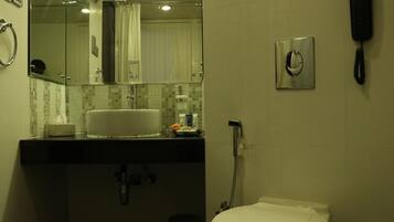 Un baño con lavamanos, espejo, inodoro y teléfono.