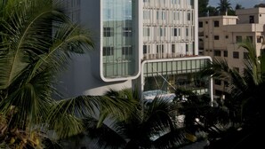 A modern building with a large glass facade and a grid-like pattern on the side. - Keys Select by Lemon Tree Hotels, Thiruvananthapuram (Thiruvananthapuram)