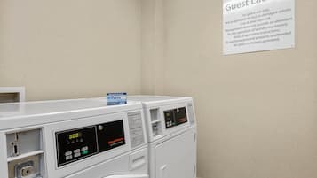 A guest laundry area with two front-loading washing machines and a sign indicating it is for guest use only.