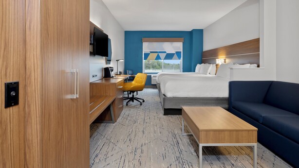 Een hotelkamer met een bed, een bureau, een stoel, een bank en een televisie.