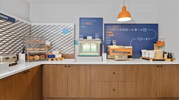 A bakery counter with a display case, a bread oven, and a sign explaining the bread-making process.