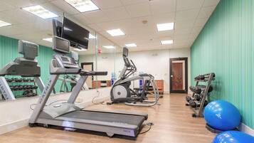 A gym with treadmills, elliptical machines, and free weights.