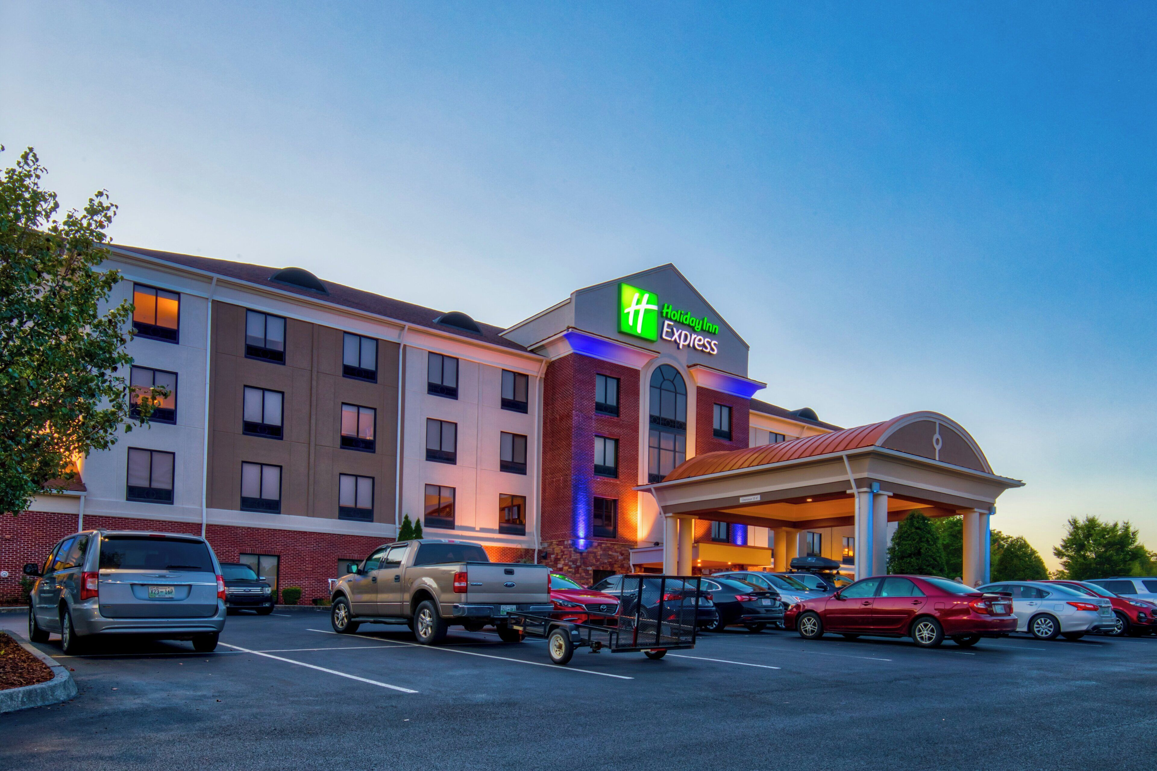 A Holiday Inn Express hotel with a parking lot full of cars.