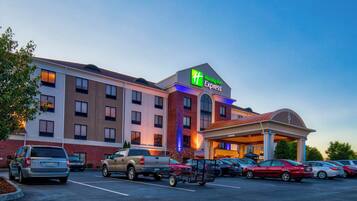 A Holiday Inn Express hotel with a parking lot full of cars.