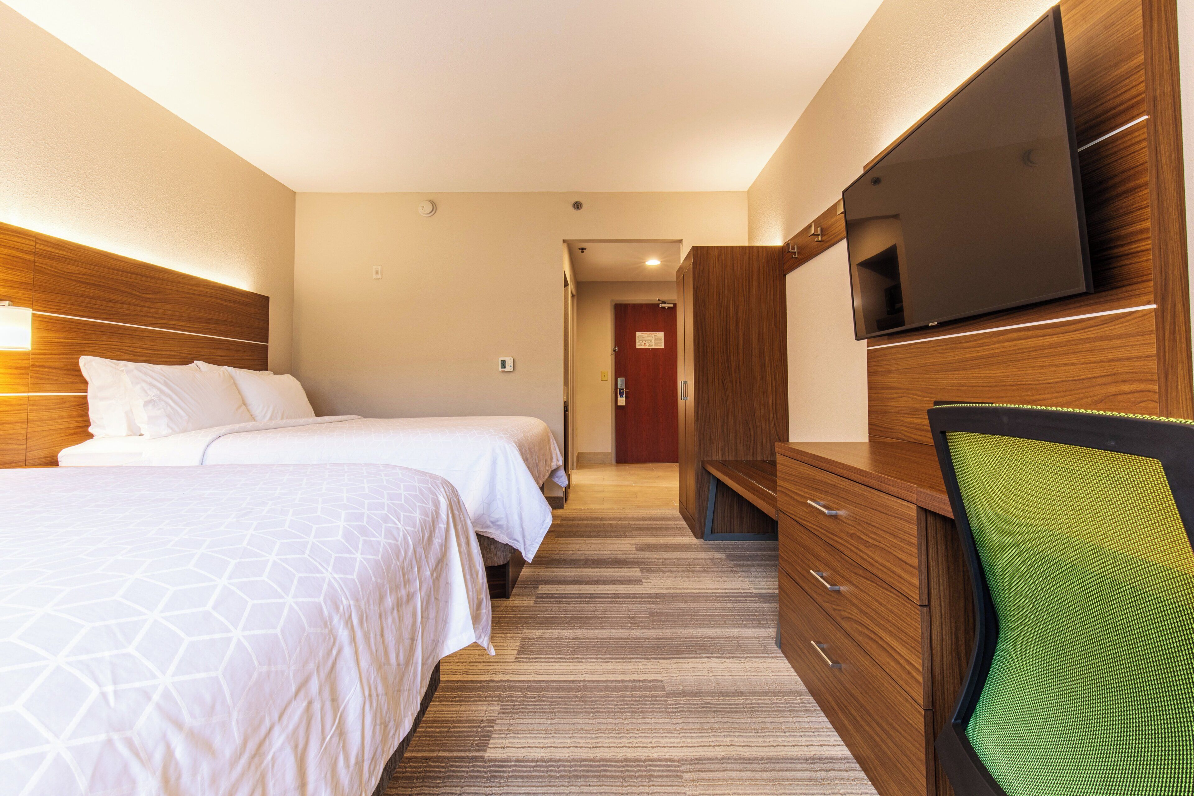 Ett hotellrum med två sängar, en TV, ett skrivbord och en stol.