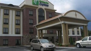 Ein Holiday Inn Express Gebäude mit Parkplatz und überdachter Eingang.