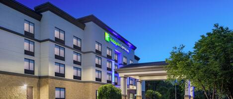A Holiday Inn Express hotel with a modern design, featuring a large parking lot and a covered entrance.