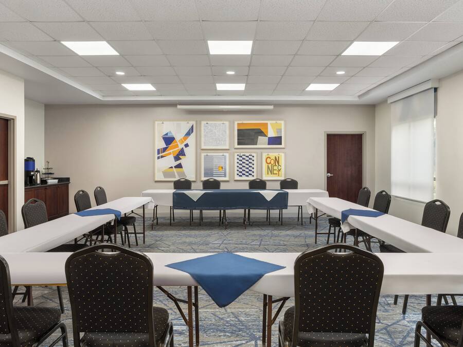 A conference room with a long table, multiple chairs, and artwork on the walls.