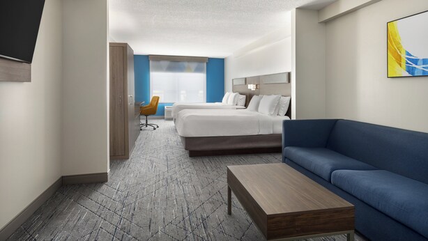 Ein Hotelzimmer mit einem Bett, einer Couch, einem Schreibtisch und einem Sessel.
