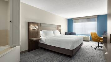 Una habitación de hotel moderna con una cama grande, un escritorio y una silla.